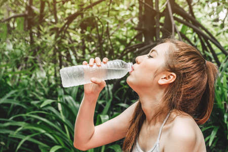 Beautiful woman drinking water on green natural fresh air.Healthy lifestyle conceptの写真素材