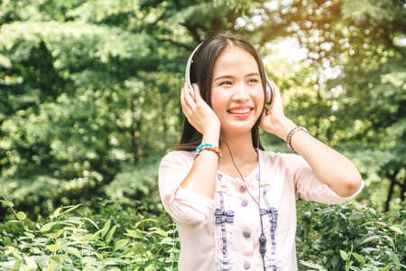 Woman relax and use smartphone sitting on grass in parkの写真素材