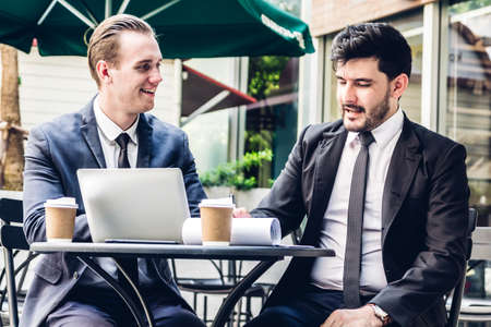 Image of two businessman working with laptop computer and discussing something together at the cafe.Businessman teamwork and Partnership conceptのeditorial素材