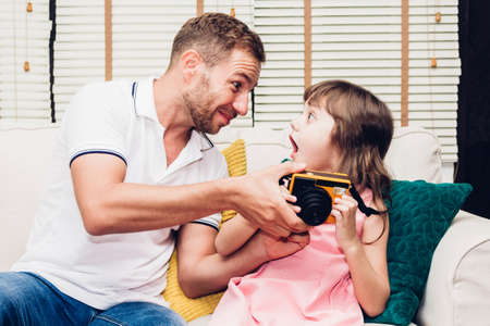 Father with little daughter having fun and playing together on the sofa at home.Love of family and...