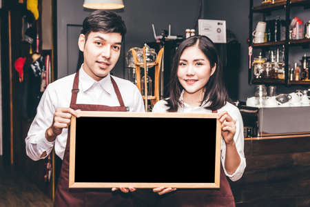 Barista holding chalkboard  in coffee shop restaurantのeditorial素材