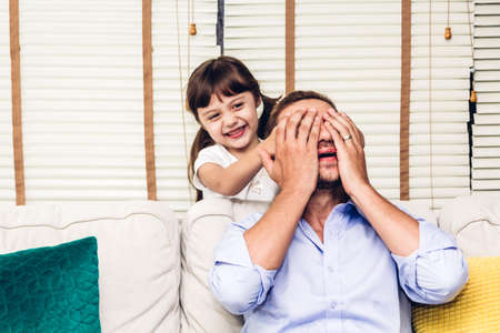 Father with little daughter having fun and playing together on the sofa at home.Love of family and...