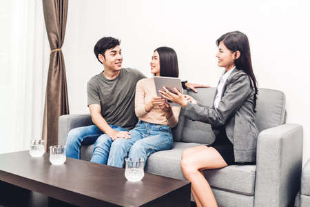 Real estate agent holding tablet and talk with young couple in a house for sale. business and real estate conceptの写真素材