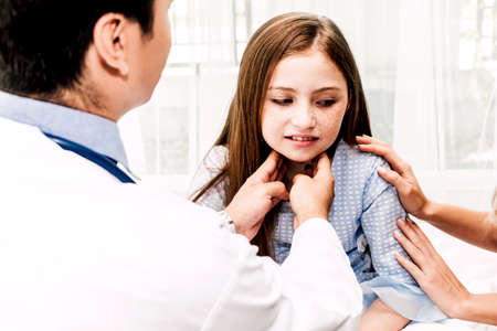 Doctor checking and examination neck pain with little girl child in hospital.healthcare and medicineの写真素材