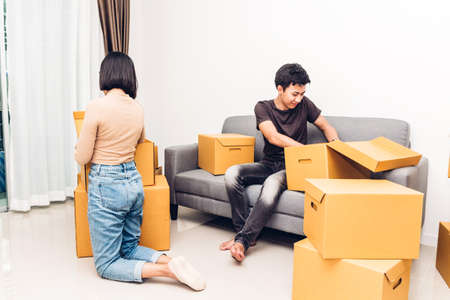 Happy young couple unpacking box and moving into their new home.House moving and real estate concept