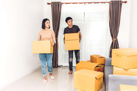 Happy young couple carrying boxes and moving into their new home.House moving and real estate conceptの写真素材