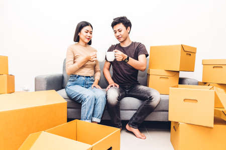 Happy young couple unpacking box and moving into their new home.House moving and real estate concept