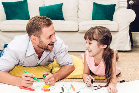 Father with little daughter having fun and do her homework at home.painting and drawing.Love of family and father day conceptの写真素材