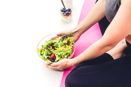 Happy fitness woman eating and holding healthy fresh salad in a bowl.dieting concept.healthy...