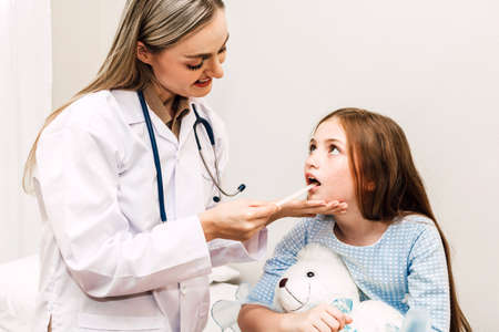 Doctor checking and examination in mouth with little girl child throat in hospital.healthcare and...