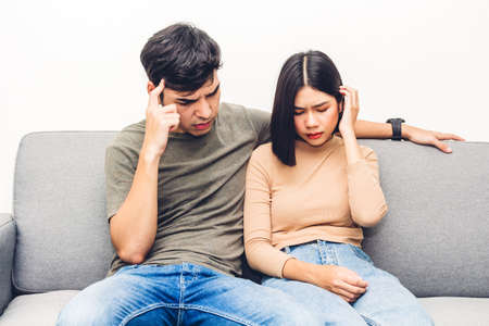 Portrait of upset couple serious quarrel together on sofa at homeの写真素材