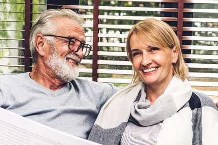 Senior couple relaxing and talking together sitting on sofa in living room at home.Retirement couple...