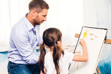 Little girl children learn to drawing on canvas with color palette and watercolor paints from the...