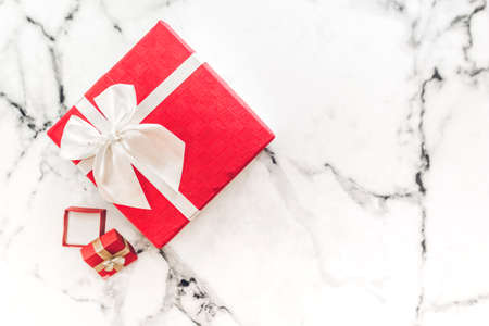Top view of red gift box and red ribbon on white marble background with space.Christmas and New year...