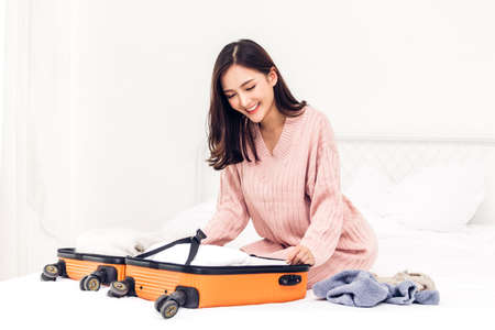Woman packing a suitcase luggage and backpack for travel at home.Holiday vacation concept