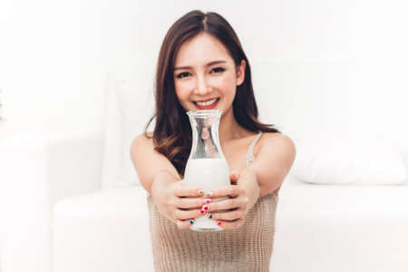 Woman hands holding glass of fresh milkの写真素材