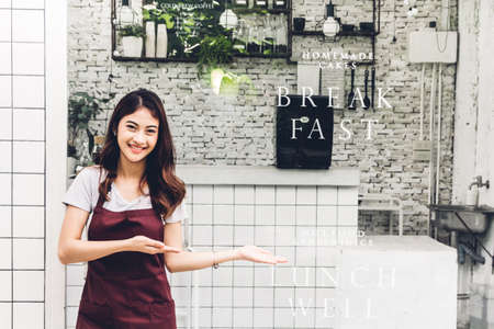 Portrait of woman small business owner smiling and standing with crossed arms outside the cafe or coffee shop.woman barista standing at cafeの写真素材
