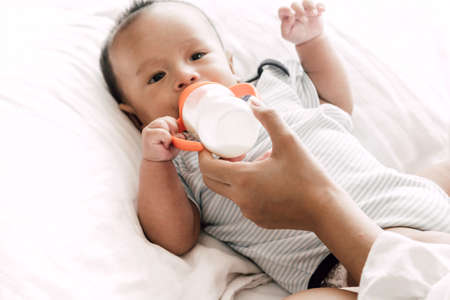 Mother feeding baby from milk bottleの写真素材