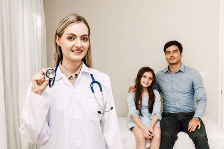 Doctor looking at camera while young family father and little girl  on background together