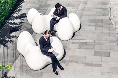 Image two business partners in black elegant suit talking and working together while discussing new strategy at city.Business and startup idea conceptの写真素材
