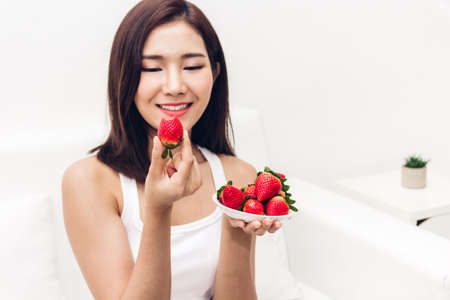 Woman eating fresh strawberry on white background.dieting concept.healthy lifestyleの写真素材