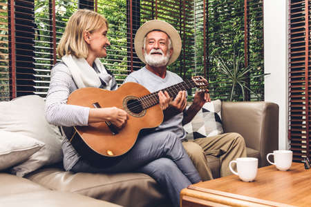 Senior couple relaxing and talking together sitting on sofa in living room at home.Retirement couple conceptの写真素材