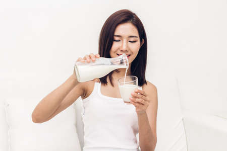 Woman hands holding glass of fresh milkの写真素材