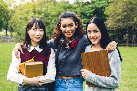 Group of smiling international students or teenagers standing and hugging together in park at university.Education and friendship Conceptの写真素材