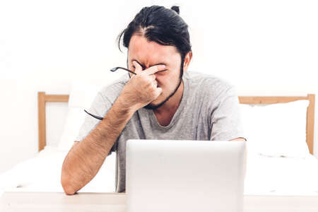 Man using digital laptop computer on the bed at home.man checking social apps and working.wireless...