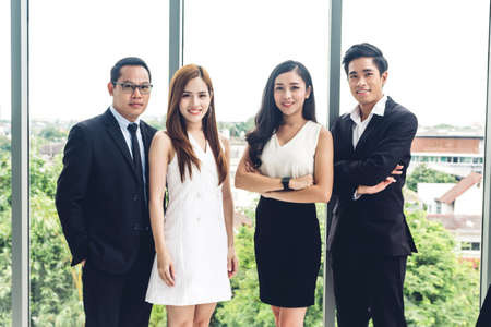 Group of professional casual business people team looking confidently at camera on glass window at...
