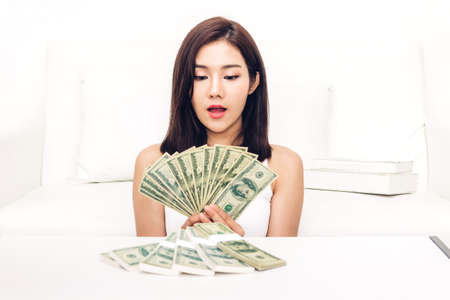 Portrait of asian woman holding a lot of money dollar bills