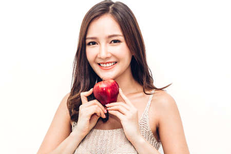 Woman holding and eating fresh red apple on white background.dieting concept.healthy lifestyleの写真素材