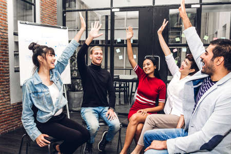 Successful of group of casual business sitting relax celebrating their triumph with arms up.Teamwork...
