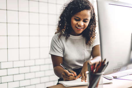 African american black woman working with laptop computer.creative business people planning and using pen in modern work loftの写真素材