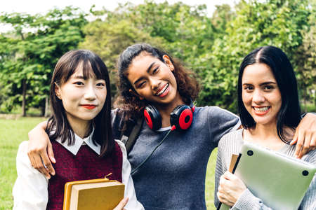 Group of smiling international students or teenagers standing and hugging together in park at university.Education and friendship Conceptの写真素材