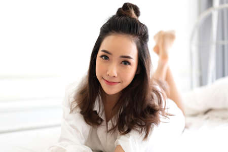 Portrait of asia woman enjoy and relax on the bed in bedroom at home.asian beautyの写真素材