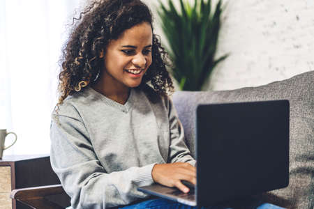 Young african american black woman relaxing and using laptop computer.woman checking social apps and working.Communication and technology conceptの写真素材