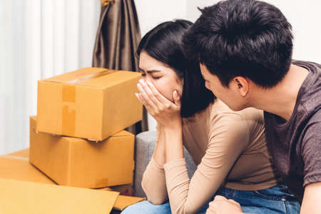 Portrait of upset couple serious quarrel together on sofa at homeの写真素材
