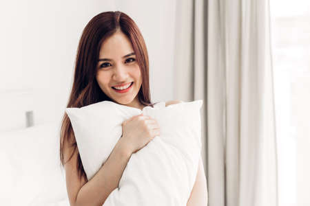 Portrait of happy smile asia woman enjoy and relax on the bed in bedroom at home.asian beautyの写真素材
