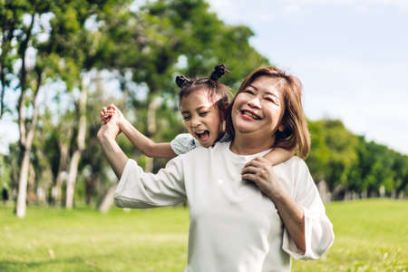 Portrait of happy grandmother and little cute girl enjoy relax together in summer park.Family and togethernessの写真素材