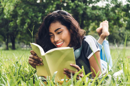 Students young woman relax and reading a book in park