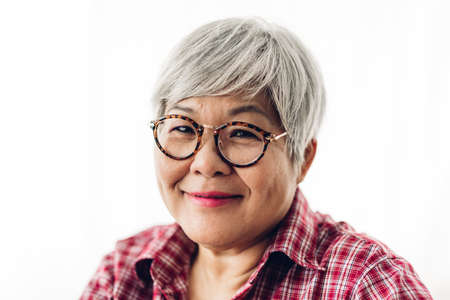 Portrait of happy senior adult elderly asia women smiling and looking at camera on white background.Retirement conceptの写真素材