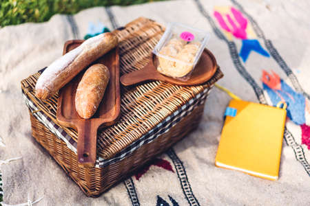 Bread and accessories summer picnic basket in the green park backgroundの写真素材