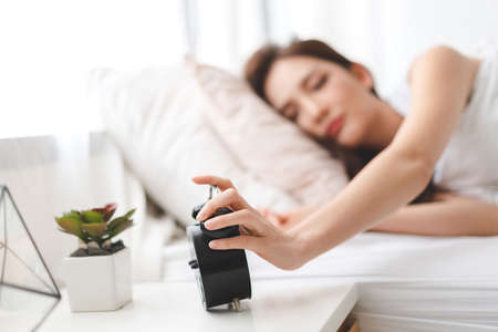 Woman drinking coffee in bedroom in the morning
