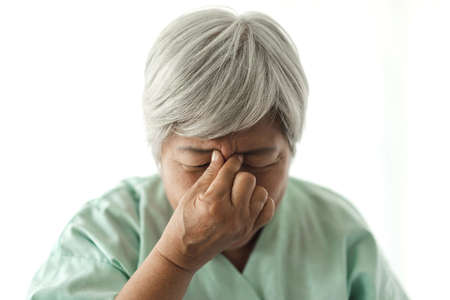 Senior adult elderly asia women serious depressed and feeling headache, thinking of problems on white backgroundの写真素材