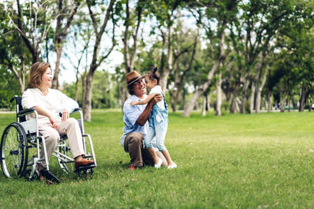 Portrait of happy grandfather with grandmother and little cute girl enjoy relax in summer park.Young...