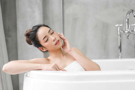 Happy woman relaxing using tablet computer on the bed at home.technology and communication conceptの写真素材