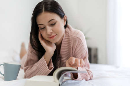 Happy woman relaxing using tablet computer on the bed at home.technology and communication conceptの写真素材