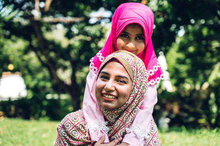 Portrait of happy lovely family arabic muslim mother and little muslim girls child with hijab dress...