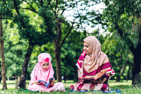 Portrait of happy muslim mother and little muslim girls child  with hijab dress smiling and enjoy relax in summer park.Education conceptの写真素材